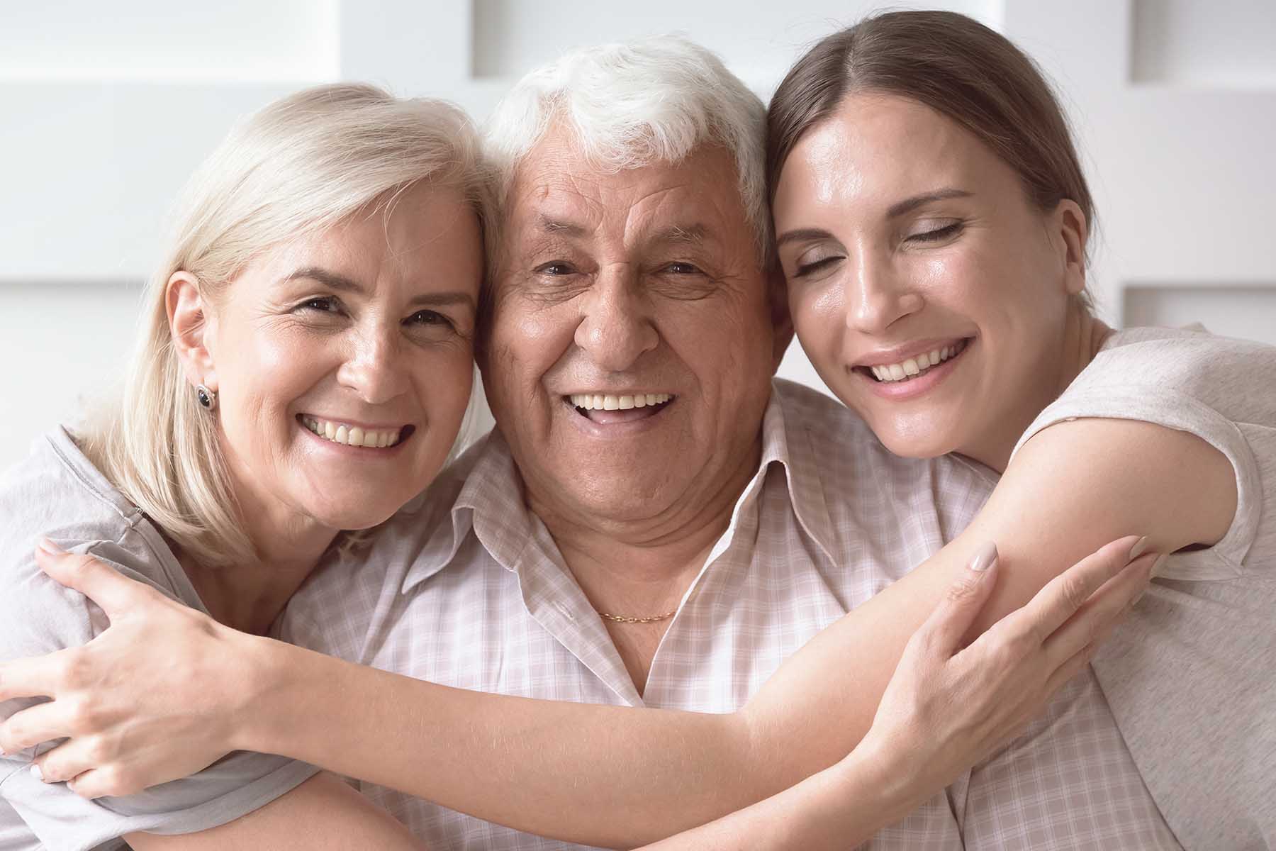 Photo of 3-generation family, smiling for a portrait.