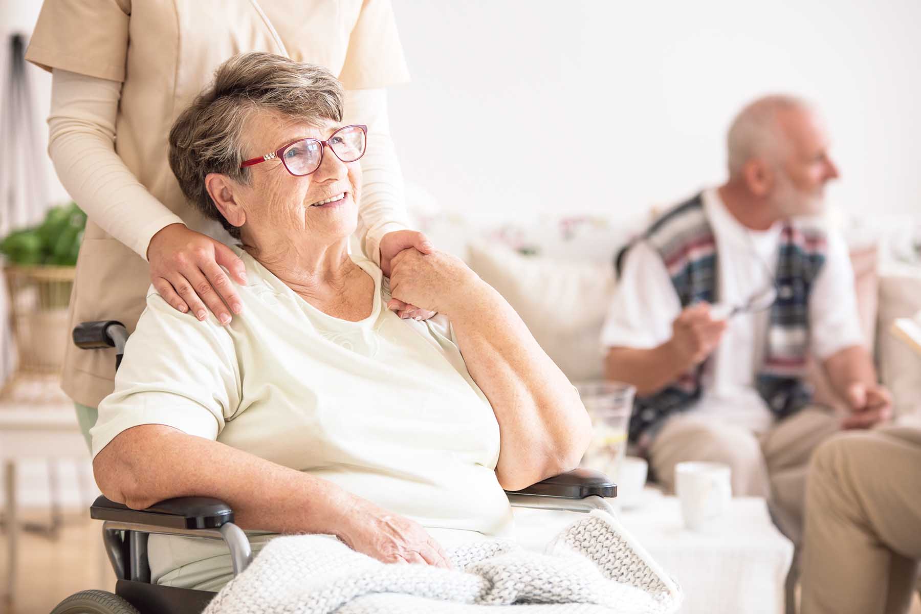 Photo of a happy-looking senior woman, sitting in a wheelchair.