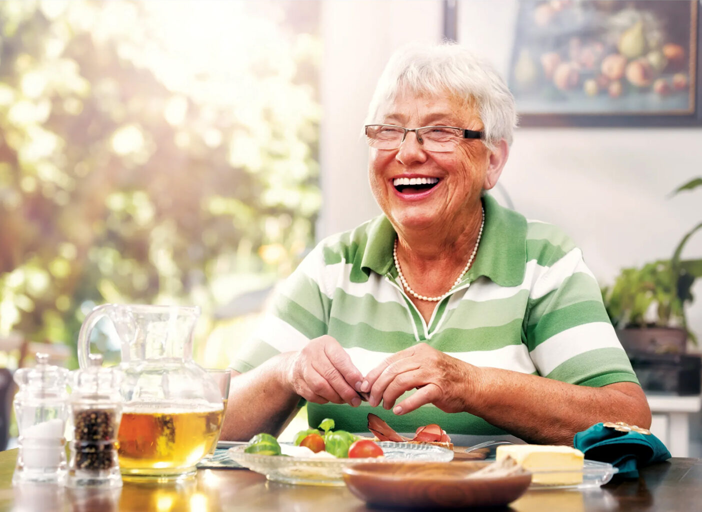 Grandmother smiling while drinking tea and eating a salad