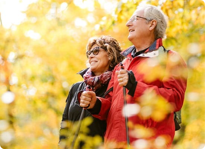 Senior man and women living an independent life while hiking in the woods