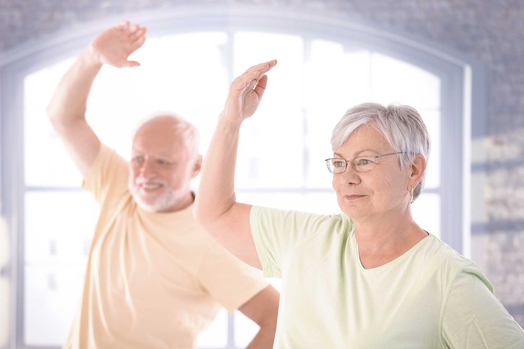 A photo of an older couple doing exercises.