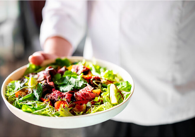 waitstaff holding plated meal