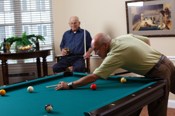 two senior men playing pool