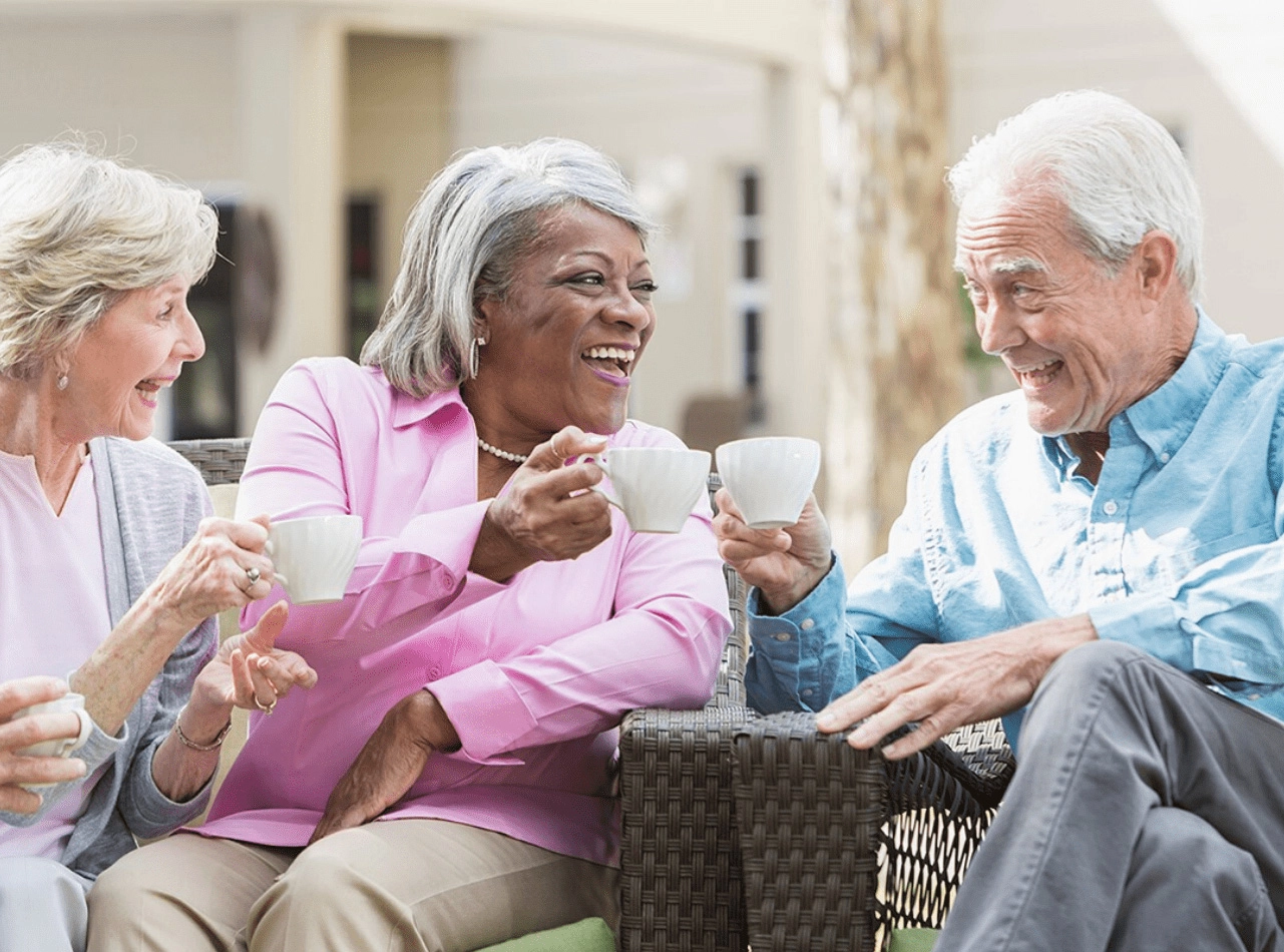 Seniors smiling outside drinking tea and coffee