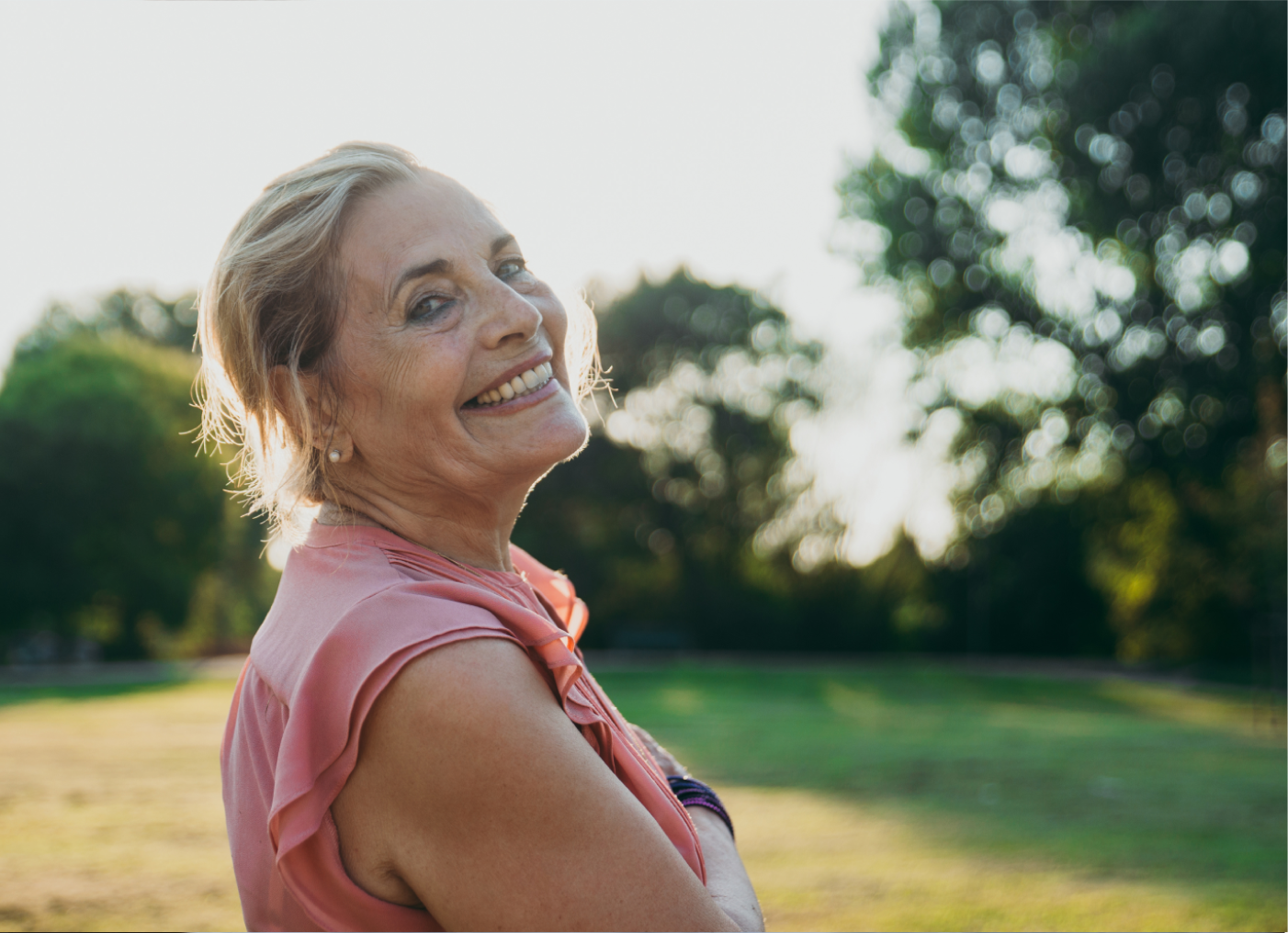 Senior women smiling as she walks around outside at The Willows Independent Living community at SALMON Health and Retirement