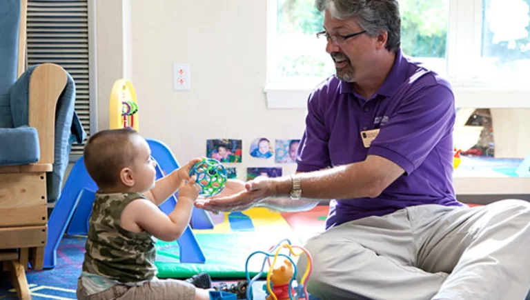 SALMON Health and Retirement staff providing early education to a toddler.