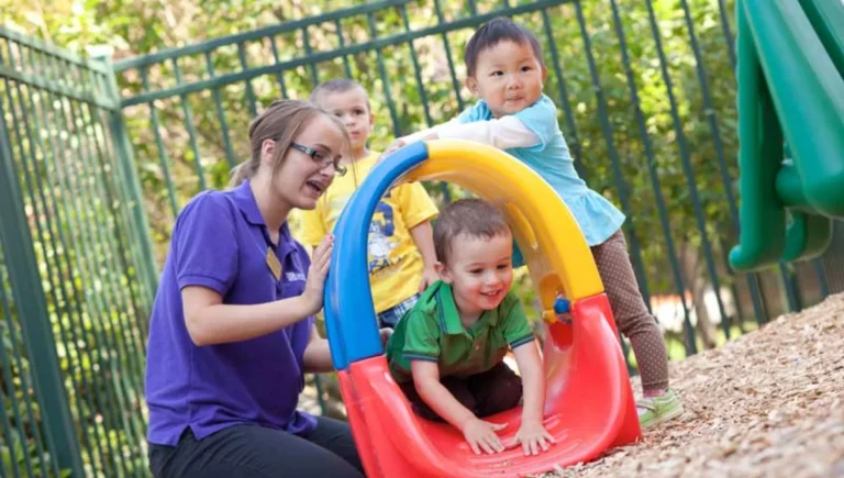 SALMON Health and Retirement staff playing outside with young children in a playground