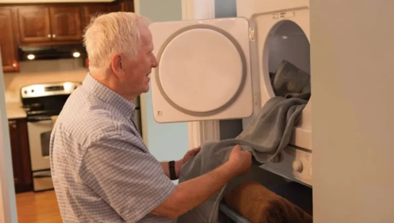 Senior man doing laundry inside his SALMON at Westborough The Willows residence