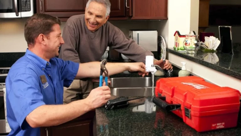 Staff maintenance man fixing a resident's sink at SALMON at Worcester The Willows