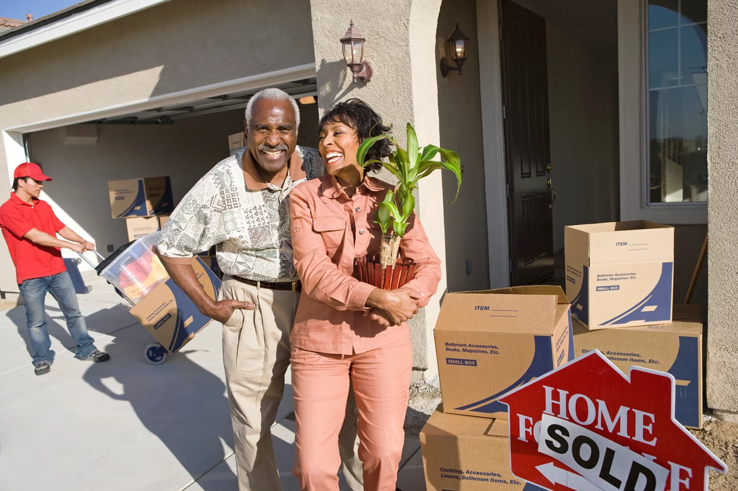 Senior couple smiling while moving out of their house